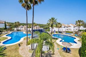 an aerial view of a pool at a resort with palm trees at Casa del Color - Alcaidesa in San Roque