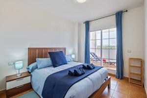 a bedroom with a bed with blue pillows on it at Casa del Color - Alcaidesa in San Roque +15 photos