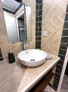 a bathroom with a white sink and a mirror at Lou Mistral - chambres de charme climatisées, centre historique in Moustiers-Sainte-Marie +10 photos