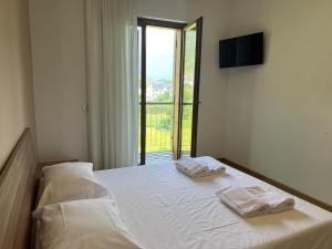 a bedroom with a bed with two towels on it at La Valle Maggiore Apt in Villa di Tirano