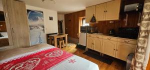 a bedroom with a bed and a kitchen in it at Le coquelicot -Draps inclus in Val Cenis