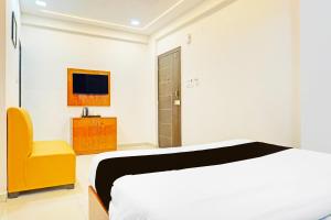 a bedroom with a bed and a yellow chair at Townhouse Surya Inn in Pune +27 photos