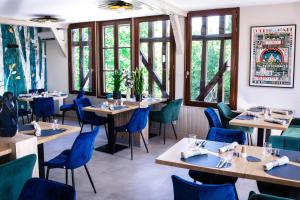 a restaurant with wooden tables and blue chairs at le saint Hubert in Arcis-sur-Aube