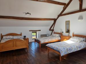 two beds in a room with wooden floors at Les Grands Gîtes de Janaillat in Janaillat +62 photos