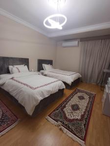a bedroom with two beds and two rugs in it at luxury apartment with 3 bedrooms in Cairo