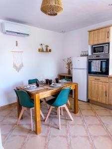 a kitchen with a wooden table and blue chairs at Petite maison indépendante au calme au cœur des oliviers in Le Beausset