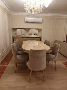 a dining room with a table and chairs and a chandelier at luxury apartment with 3 bedrooms in Cairo +12 photos