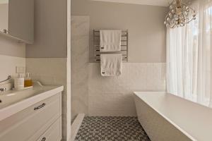 a white bathroom with a tub and a sink at Henderson House in Saratoga +18 photos