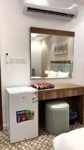 a room with a bed and a mirror and a cooler at Roaa Al-Jamwaut in Al Madinah
