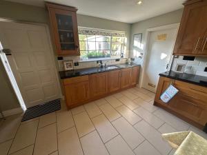 a large kitchen with wooden cabinets and a sink at Richmond Cottage Beag in Blackrock