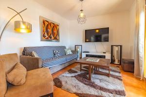 a living room with a couch and a table at Caparica Beach Stay in Costa da Caparica