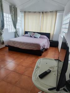 a bedroom with a bed and a table with a remote control at Caparica Beach Stay in Costa da Caparica