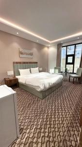 a bedroom with a large bed and a large rug at Roaa Al-Jamwaut in Al Madinah