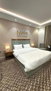 a large white bed in a hotel room at Roaa Al-Jamwaut in Al Madinah