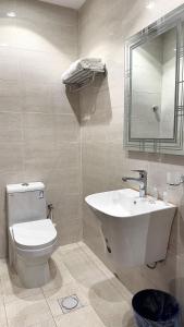 a bathroom with a sink and a toilet and a mirror at Roaa Al-Jamwaut in Medina