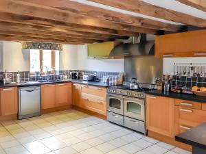 a large kitchen with wooden cabinets and appliances at La Grande Maison de Janaillat in Janaillat
