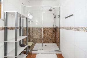 a shower with a glass door in a bathroom at Caparica Beach Stay in Costa da Caparica +22 photos