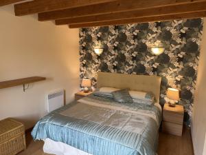 a bedroom with a bed and two lights on the wall at La Grande Maison de Janaillat in Janaillat