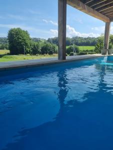 a swimming pool with blue water at La Grande Maison de Janaillat in Janaillat +12 photos