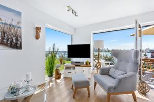 a living room with a tv and a chair at Pamir in Kappeln