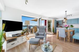 a living room with a television and a dining room at Pamir in Kappeln