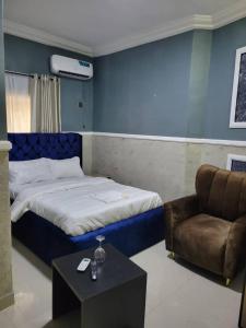 a bedroom with a bed and a chair and a table at International Royal Hotel in Owerri