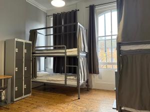 ロンドンにあるCricketers Hostelの二段ベッドが2つと窓のある部屋