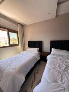 two beds sitting next to each other in a bedroom at Residence Plaza de Toros in Tangier