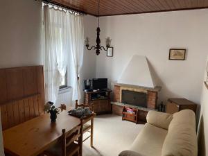 a living room with a couch and a table and a fireplace at Vittoria 1920 - hotel restaurant apartaments in Marzio