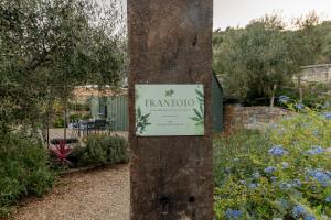 a sign on a tree in a garden at FRANTOIO - Suite nel verde con giardino e terrazza privata in Taggia