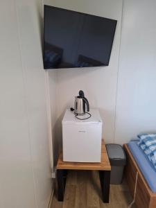 a coffee maker on a table in a room with a tv at Štúdio Comfort 
