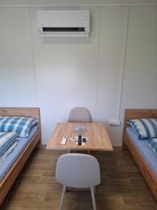 a room with two beds and a table and a chair at Štúdio Comfort 