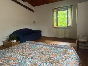a bedroom with a blue bed and a window at Accogliente dimora tra le colline in San Cipriano