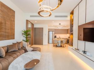 ein Wohnzimmer mit Sofa und Tisch in der Unterkunft Ahlan HH - Burj Khalifa and Fountain Views Suite at Grande Downtown in Dubai