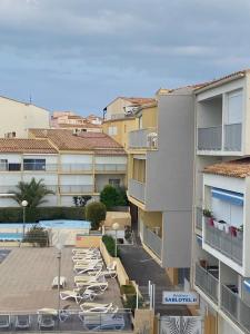 a group of lounge chairs sitting next to a building at Apartment with pool included in Agde