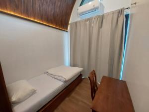 a small room with a bed and a table at Villa Saung Wira in Cirebon