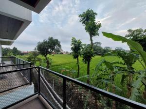 a balcony with a view of a green field at Villa Saung Wira in Cirebon