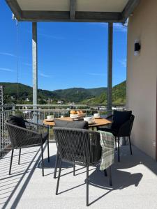a table and chairs on a balcony with a view at Ferienwohnungen Moselpanorama in Bullay