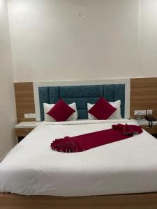 a bedroom with a large white bed with red pillows at Hotel Apple Rose Near Harish Dhaba in Chandīgarh
