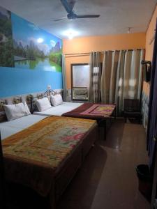 a bedroom with two beds and a painting on the wall at Hotel Apple Rose Near Harish Dhaba in Chandīgarh +6 photos