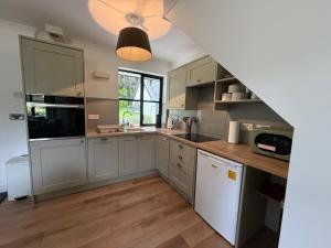 a kitchen with gray cabinets and wooden floors at Highland Nook in Fort William