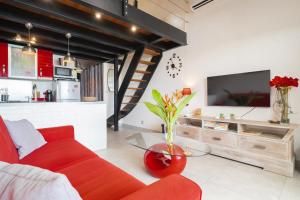 a living room with a red couch and a glass table at Appartement Honoré in Saint-François