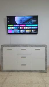a flat screen tv on top of a white cabinet at Playa de las Américas Las Floritas con piscina in Playa de las Americas +19 photos