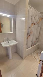a white bathroom with a sink and a mirror at Playa de las Américas Las Floritas con piscina in Playa de las Americas