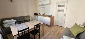 a living room with a table and a couch and a kitchen at Mazurska ostoja in Kętrzyn +9 photos