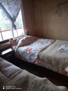 Dos camas en una habitación con ventana. en cabañita Campestre, independiente, en Castro