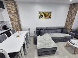 a living room with a couch and a table and chairs at New Comfort Apartment in Golem