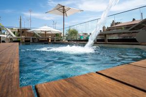 een fontein in een zwembad met een tafel en een parasol bij Zenit Borrell in Barcelona
