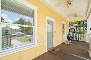 a home with a porch with a large window at NEW Lakeland Landing - Adorable Bungalow In Prime Location in Lakeland