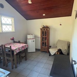 a kitchen with a table and a table and a refrigerator at Chalé da Araucária in Campos do Jordão